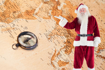 Santa shows something to camera against world map with compass showing southern asia