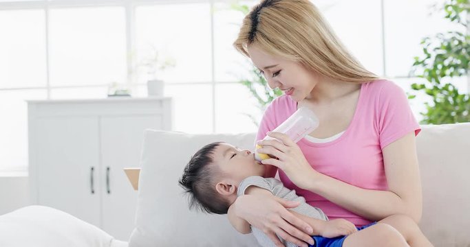 mom feeding milk to son