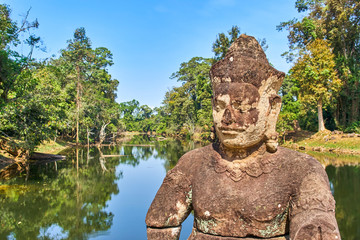 Stone statue of guardian Asura on the bridge that crosses the moat surrounding Preah Khan temple, Angkor, Cambodia