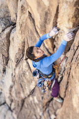 Rock climber clinging to a cliff. © Greg Epperson