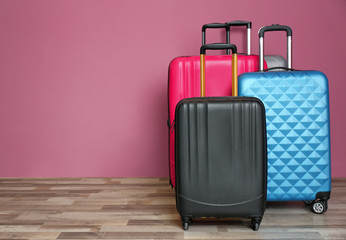 Different suitcases near color wall