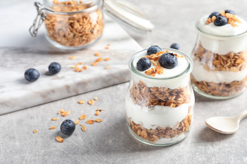 Jars with yogurt, berries and granola on  table