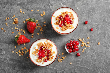 Glasses with yogurt, berries and granola on table, top view