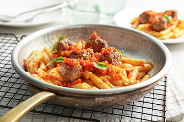 Pasta with meatballs and tomato sauce on table