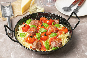 Pasta with meatballs and tomato sauce on table