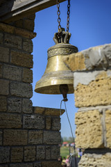 Obraz premium a copper bell hanging on a chain in a bell tower