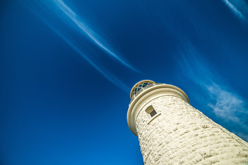 Looking up at blue sky with white lighthouse in scene © jodie777