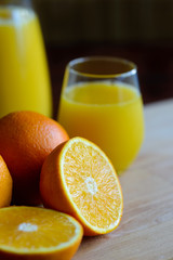 Oranges cut and set on wooden cutting board with fresh juice