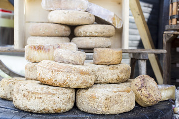 rustic french cheese wheels stacked on the marketplace