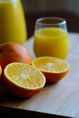 Oranges cut and set on wooden cutting board with fresh juice