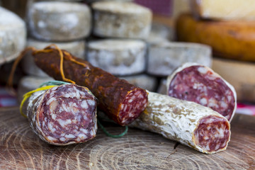 rustic french cheese wheels and salami stacked on the marketplace