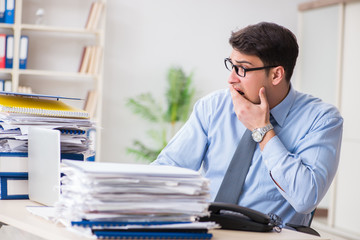 Extremely busy businessman working in office