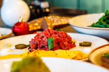 Raw beef Tartar lies on a plate on the table