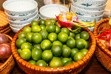Lime lie in a basket on the counter in the lacquer of Chinese food