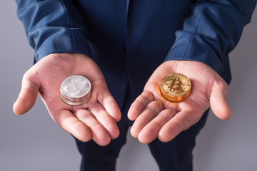 In one hand silver bitcoins, and in another gold bitcoins