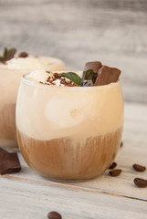 Iced Mocha Coffee with Whip Cream, Summer Drinking times. Coffee Beans. rustic textured Wooden Background. Mint Leaves
