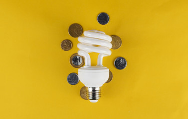 Lamp and coins isolated in yellow background.