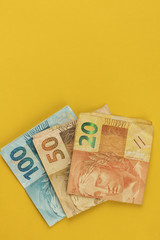 Obraz premium Varied values of Brazilian money isolared on yellow background