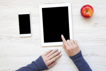 Feminine workspace with smartphone, tablet and apple. Top view. From above.
