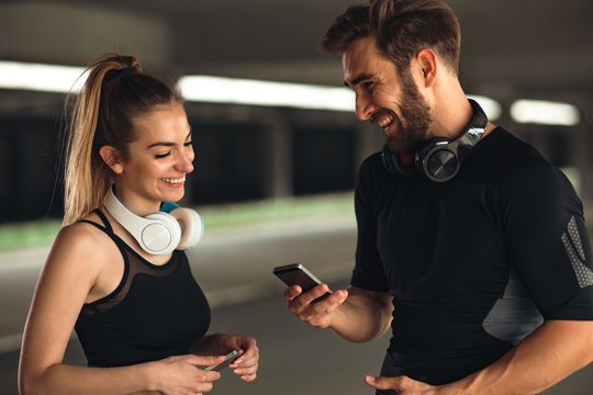 Young sports couple listening to music before workout