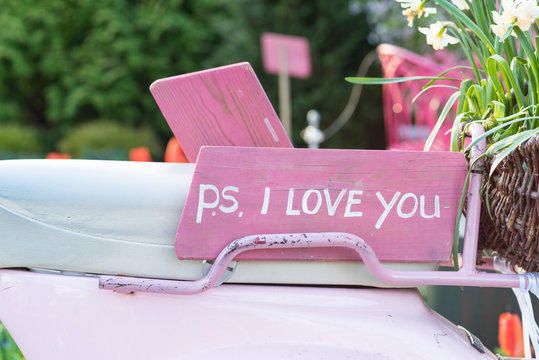 Pink sign on the seat of a scooter saying 'P.S. I love you'