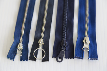 metal and plastic threaded blue zippers on the white background for textile concept. 