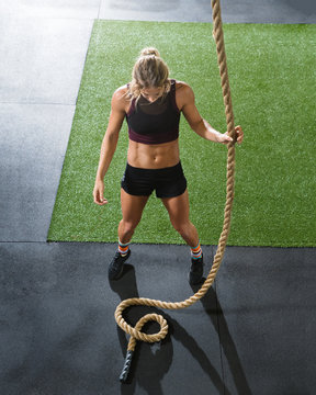 Woman tackling the rope climb during interval training workout