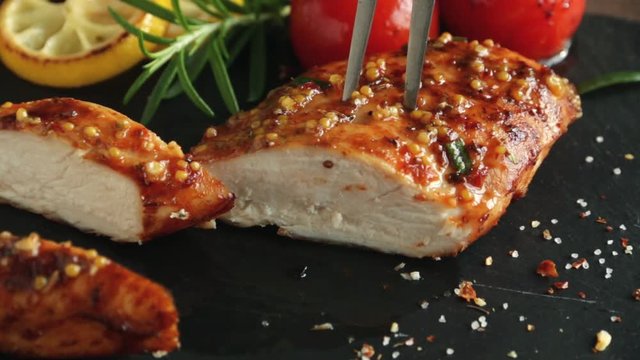 cooking fried roasted chicken breasts cut knife with lemon tomato and rosemary mustard seeds honey