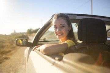 Naklejka premium Smiling woman driving a car