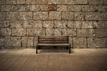 Wooden bench at the wall - dark brown grunge background