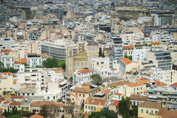 Fototapeta na wymiar View from above on the streets and roofs of the houses of a modern European city. Athens summer day from a height.