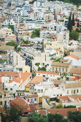 Fototapeta na wymiar View from above on the streets and roofs of the houses of a modern European city. Athens summer day from a height.