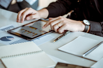 Businessman use tablet computers to connect with the word for analyse economics trade. He is married.