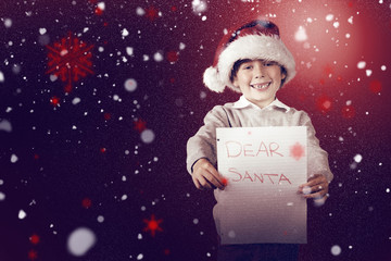 Festive boy showing letter against snow