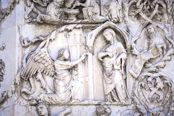 Detail of the facade of the Duomo of Orvieto, Italy. Marble bas-relief representing episodes of the bible.Annunciation