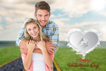 Attractive young couple smiling at camera against cloud heart