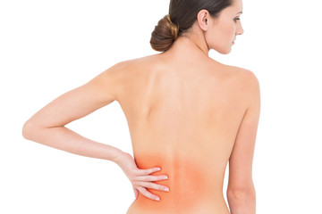 Rear view of a fit topless young woman with back pain standing over white background