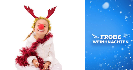 Cute little girl wearing red nose and tinsel against blue vignette