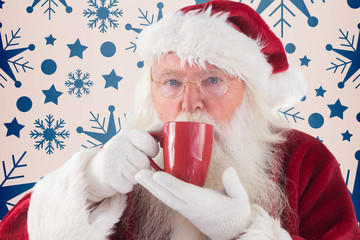 Santa drinks from a red cup against snowflake pattern