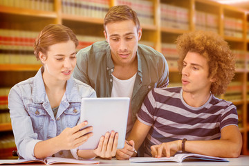 Obraz premium Fashion students using tablet against close up of a bookshelf