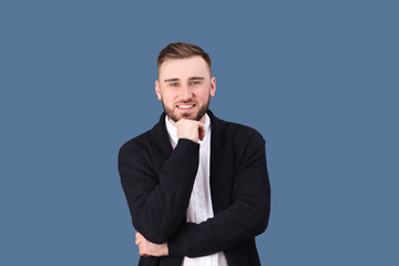 Portrait of confident young man on color background