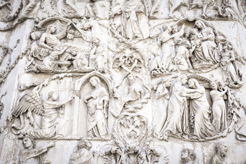 Fototapeta na wymiar Detail of the facade of the Duomo of Orvieto, Italy. Marble bas-relief representing episodes of the bible