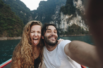Couple taking selfie on a longtail boat - Powered by Adobe
