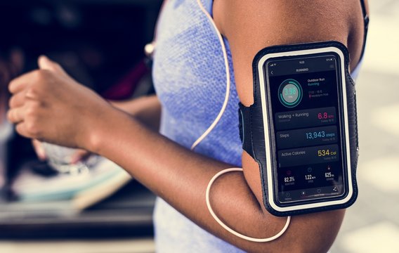 Healthy woman exercising while using technology
