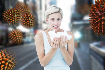 Sick woman holding tissues looking at camera  against blurry new york street
