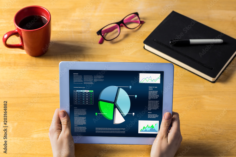 Poster businesswoman using tablet at desk showing business interface with graphs and data