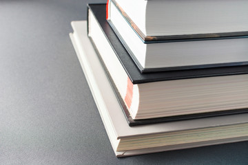 Stack of thick books on a gray background
