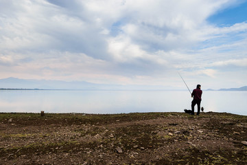 Fototapeta na wymiar Lonesome fisherman traveler being reflected in Convento Viejo Dam, VI Region near Chimbarongo, Chile