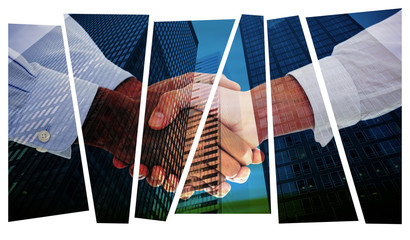 Close-up shot of a handshake against low angle view of skyscrapers