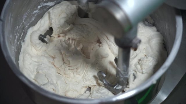 4K Movie of Flour, White Eggs and Water  in dough mixing machine, bakery ingredient mixed in the machine